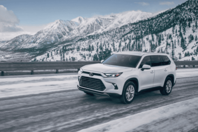 white Toyota highlander driving on snowy highway